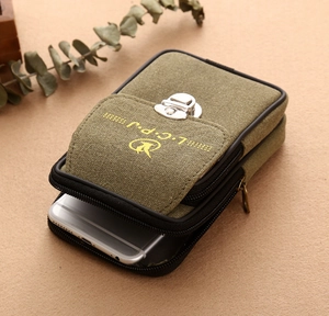 Detail showing the military green canvas waist bag with dual zippers and front flap