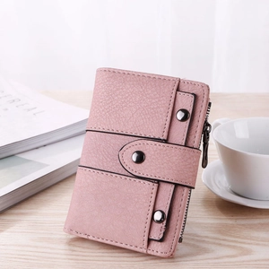 Detail of light pink tri-fold wallet showing neat stitching and vintage stud accents