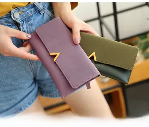 Detail of matte finish trifold long wallets with gold V-shape metal hardware accent