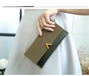 Detail of color-block frosted long wallet with gold V-buckle held by model