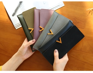 Detail of color-blocked long trifold wallets for women with elegant gold V-shape buckle