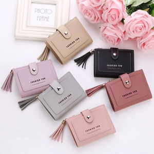 Short women wallets in multiple colors with tassels and leather texture shown on desk
