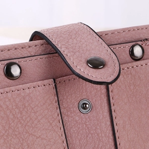 Macro shot of litchi grain faux leather texture with metal rivet details and snap button