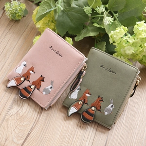 Detail of cute cat and fox embroidery on pastel faux leather mini wallets with pompom charm