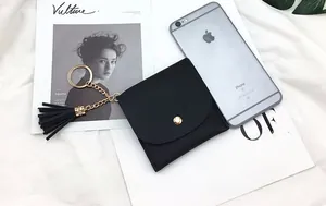 Detail of black pebbled PU leather coin purse with golden clasp and tassel keychain