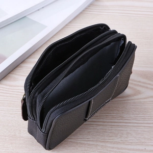 Three-zipper black leather waist bag with multi-layer compartments on wood background