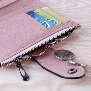 Detail view of pink leather wallet featuring multiple card slots and a secure coin pocket