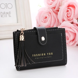 Close-up of black leather wallet with golden buckle, tassel charm and fashion lettering