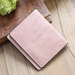 Pink minimalist faux leather bi-fold short wallet for women on a wooden background