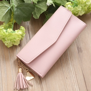 Detail der rosa Damen-Geldbörse mit Litschi-Maserung, Quaste und goldenem Herzanhänger
