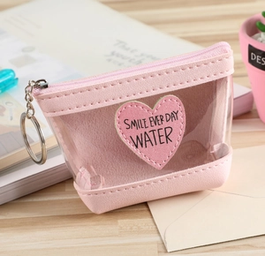 Porte-monnaie transparent rose en forme de cœur avec porte-clés sur table en bois