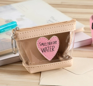Détail du mini porte-monnaie avec broderie cœur, PVC transparent et porte-clés