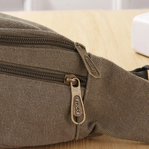 Detail of brown oxford fabric waist bag featuring dual zippers with bronze SPORT engraving
