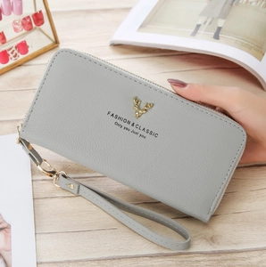 Close-up of light grey litchi texture wallet featuring a golden deer head ornament