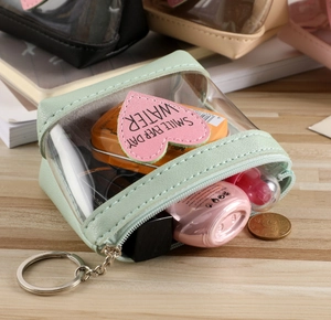 Détail du mini porte-monnaie en PVC transparent vert menthe avec écusson cœur et porte-clés