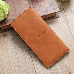 Detail of the orange leather long wallet with stitching on a rustic wooden table