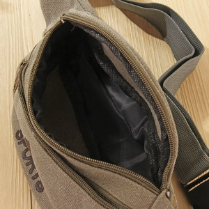 Detail of army green oxford cloth waist bag showing inner mesh pocket and metal zipper