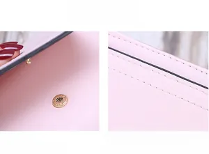 Detail of pink trifold wallet showing magnetic snap button and precise double stitching