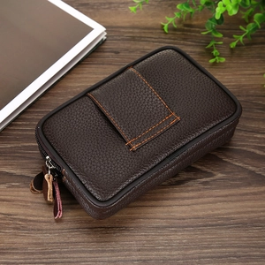 Detail of dark brown lychee pattern leather waist bag with double zippers on wooden table