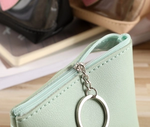 Détail du porte-monnaie vert menthe avec texture litchi et fermeture éclair à anneau