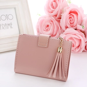 Close-up of pink pebbled leather short wallet with tassel pendant and snap buckle