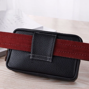 Detail of a black leather belt pouch with a wide loop, featuring a lychee grain texture