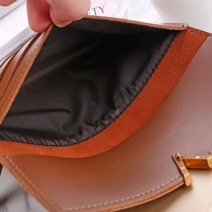 Macro detail of the brown leather wallet interior with fine stitching and gold fastener