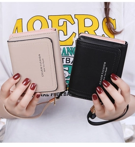 Detail view of tri-fold leather wallets with wristlets in beige and black colors