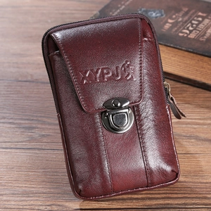 Detailed view of wine red leather phone holster with metal buckle on wooden surface