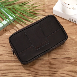 Detail of dark brown leather phone holster with wide belt loop on a wooden background