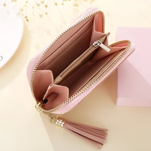 Détail du portefeuille à pompons rose avec fentes pour cartes et poche à monnaie