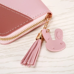 Détail du portefeuille en cuir bicolore rose et marron avec pompon lapin doré