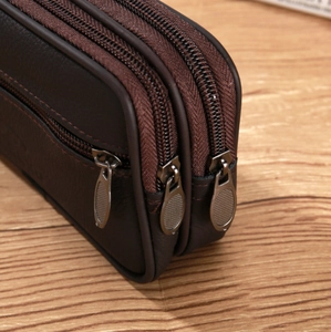 Close-up of brown leather waist bag showing three-layer zipper compartments and texture
