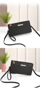 Detail view of black quilted crossbody bag with gold logo and dual-layer zipper structure