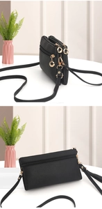 Detail of black crossbody bag with litchi texture and triple zipper gold ring pulls