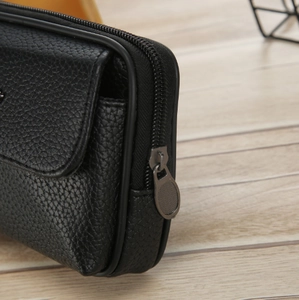 Close-up of black lychee grain PU leather pouch with zipper and buckle detail