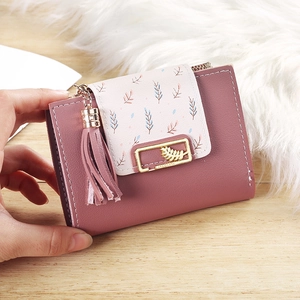 Pink short bifold wallet with leaf pattern, tassel pendant, and stylish gold hardware