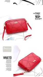 Detailed view of red crossbody bag featuring geometric stitching and gold logo accent