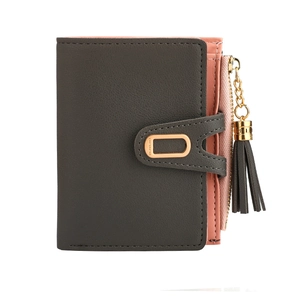 Short bifold wallet detail showing black leather exterior and pink tassel zip pocket