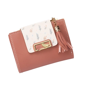 Detail of short leather wallet with leaf print, tassel, and golden metal leaf charm