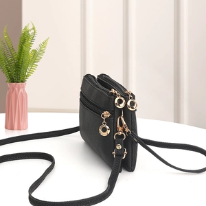 Black pebbled faux leather crossbody bag with three zipper compartments and gold hardware