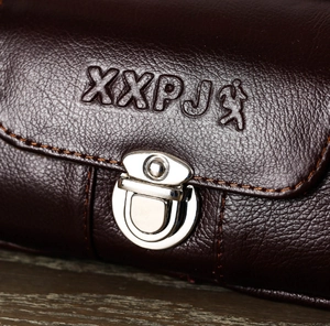 Close-up of brown textured leather waist bag featuring a polished silver metal buckle