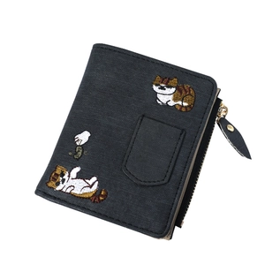 Detail of black wallet with cute cat embroidery and textured faux leather finish