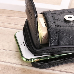 Close-up of a men's black leather waist bag showing dual-layer storage and quilted stitching