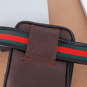 Detail der braunen Gürteltasche aus Leder mit markantem grün-rotem Webband an der Rückseite