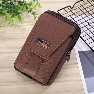 Close-up of brown canvas waist bag with SPORT metal tag and durable zipper detail
