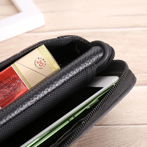 Macro shot of black pebbled leather phone pouch with U-shape zipper and interior storage