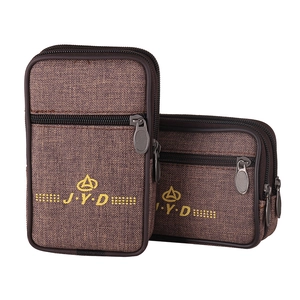 Detailed close-up of brown canvas waist bags with multiple layers and J.Y.D embroidery