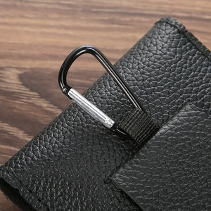 Detail of black lychee grain leather phone pouch featuring a sturdy metal carabiner clip