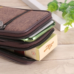 Detail view of coffee canvas waist bag showing multi-layer zippers and smartphone storage